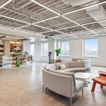 Unilever's company store with products on shelves, and a curved gray couch sitting area. The windows feature view of NYC skyline. (Photo: Unilever)